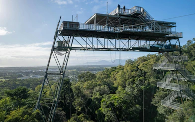 Skypark Cairns tower overlooking lush forest and distant mountains.
