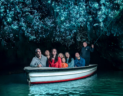 Group in boat under glowworms at Waitomo Caves, New Zealand.