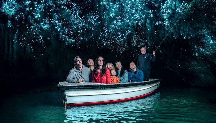 Group in boat under glowworms at Waitomo Caves, New Zealand.