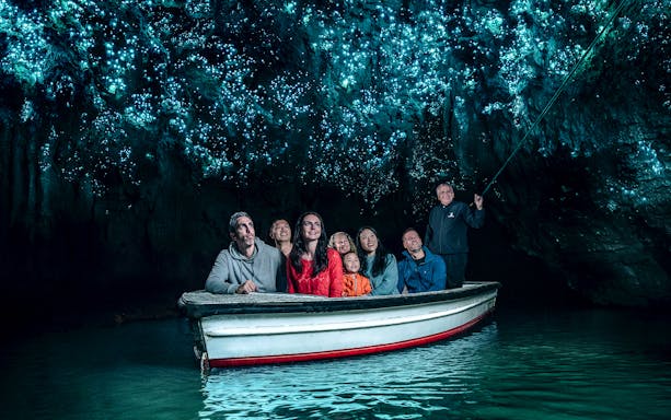 Group in boat under glowworms at Waitomo Caves, New Zealand.