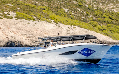 Speedboat cruising near rocky coastline during Blue Lagoon, Duga Bay & Trogir Boat Tour.