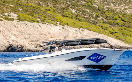 Speedboat cruising near rocky coastline during Blue Lagoon, Duga Bay & Trogir Boat Tour.
