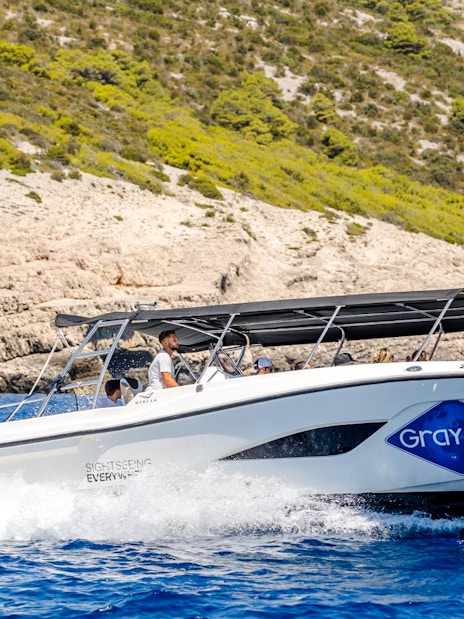 Speedboat cruising near rocky coastline during Blue Lagoon, Duga Bay & Trogir Boat Tour.