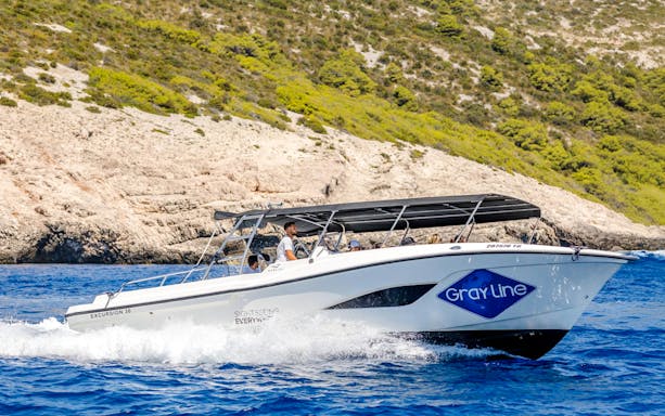 Speedboat cruising near rocky coastline during Blue Lagoon, Duga Bay & Trogir Boat Tour.