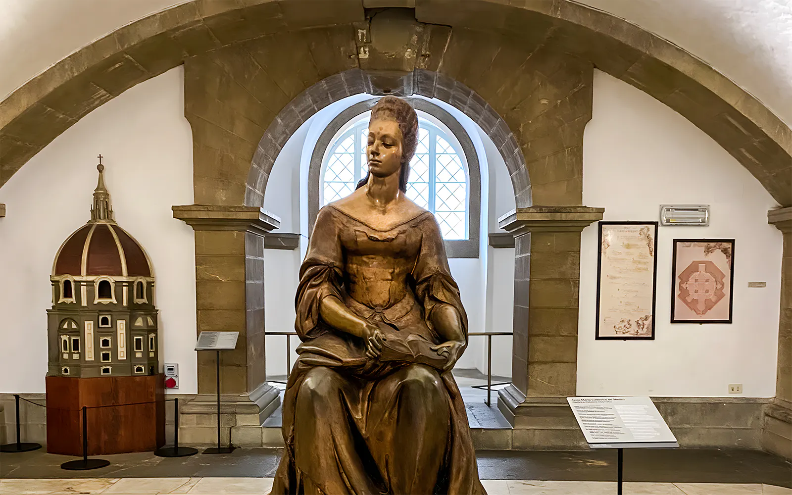 Statue inside Medici Chapel, Florence, with architectural model and historical displays.