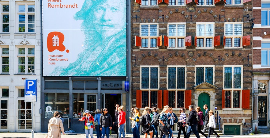 Exteriors of Rembrandt House Museum in Amsterdam with visitors walking by.