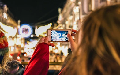Person photographing London Christmas lights from Tootbus tour.