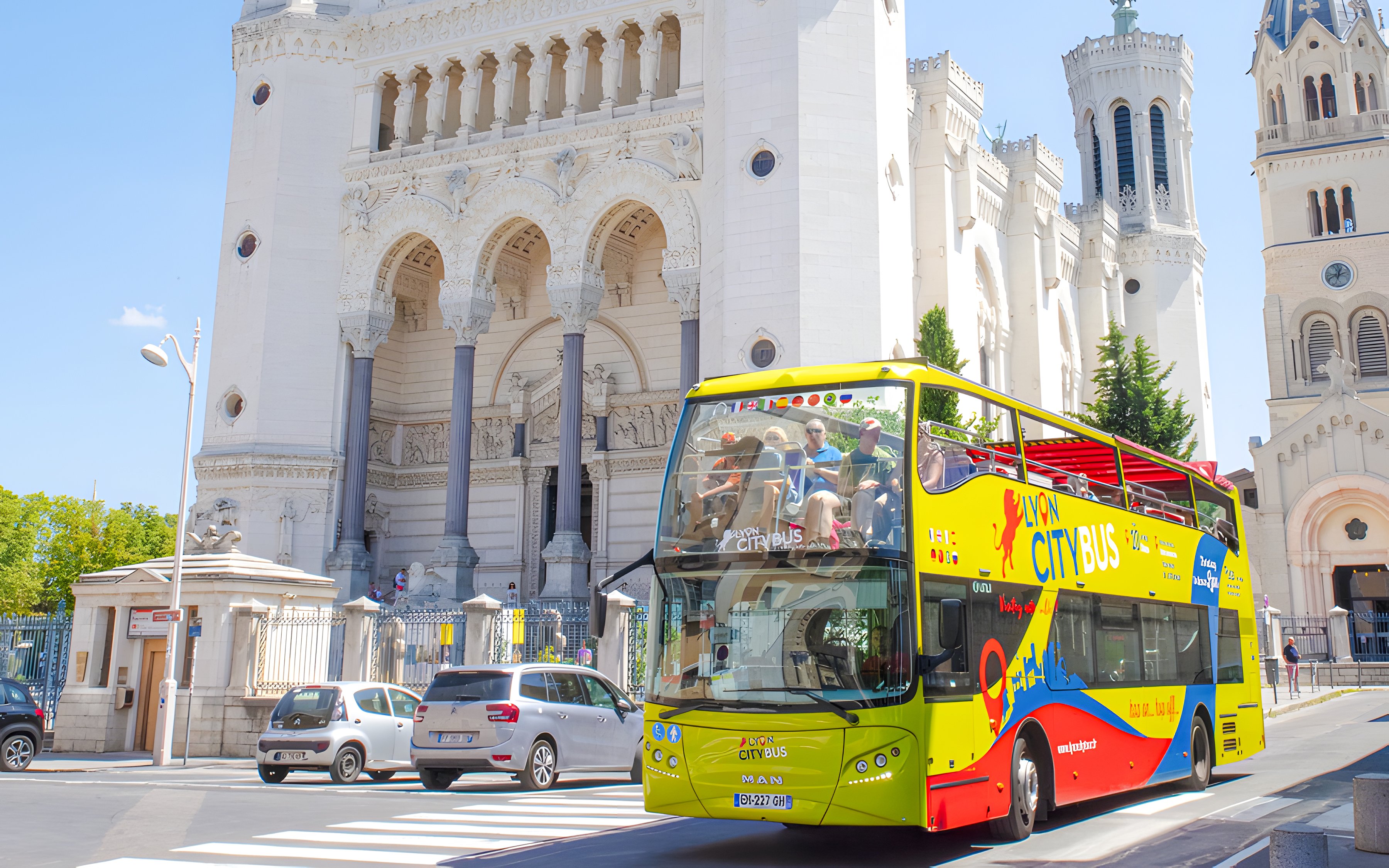 Lyon city tour bus in front of Basilica of Notre-Dame de Fourvière, France.