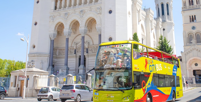 Lyon city tour bus in front of Basilica of Notre-Dame de Fourvière, France.