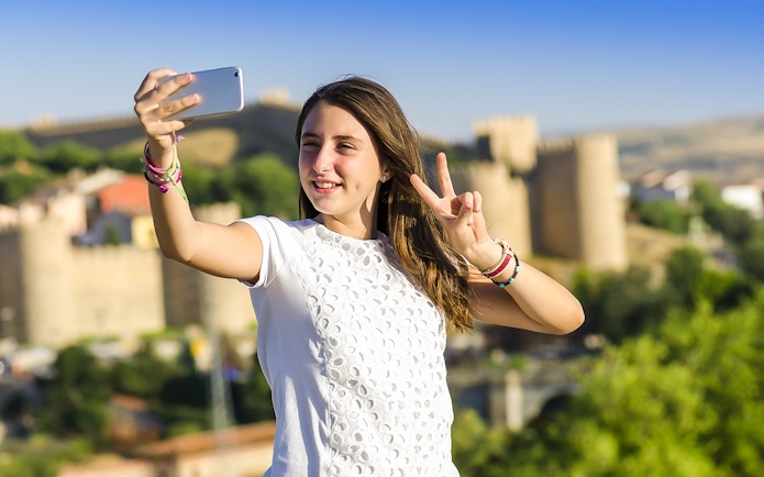 Person taking a selfie with Avila city walls in the background during Segovia & Avila day trip.