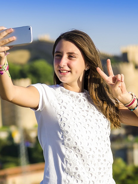 Person taking a selfie with Avila city walls in the background during Segovia & Avila day trip.