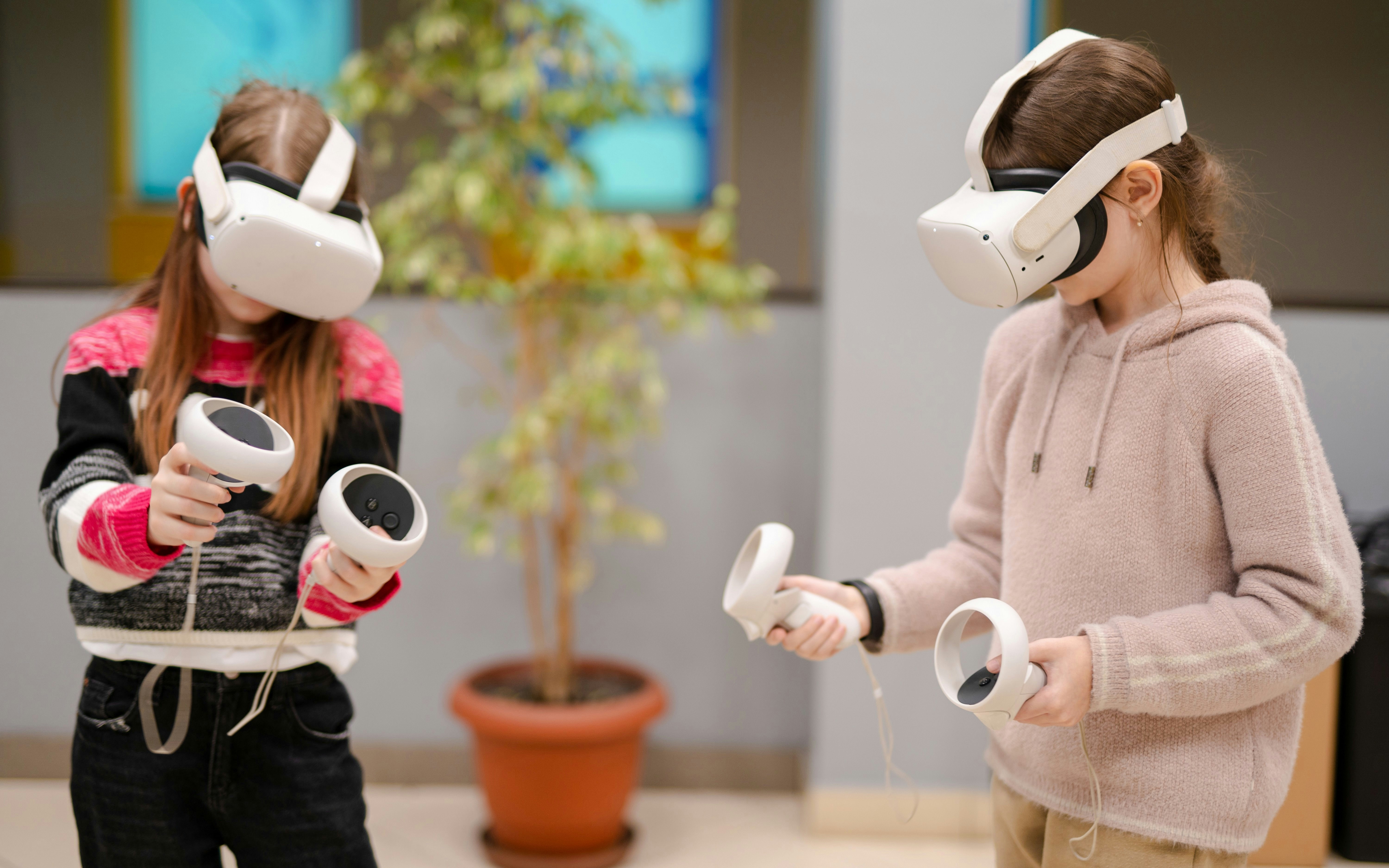 Children using virtual reality headsets and controllers indoors.