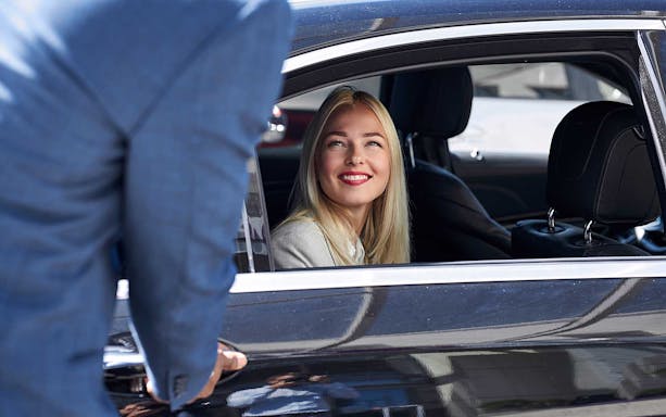 Passenger smiling in car during shuttle service between Monreale and Palermo.