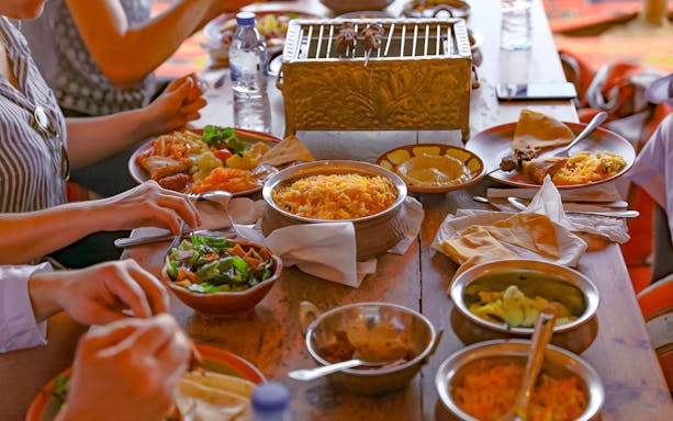 Traditional meal served during Abu Dhabi desert safari with rice, salad, and grilled meat.