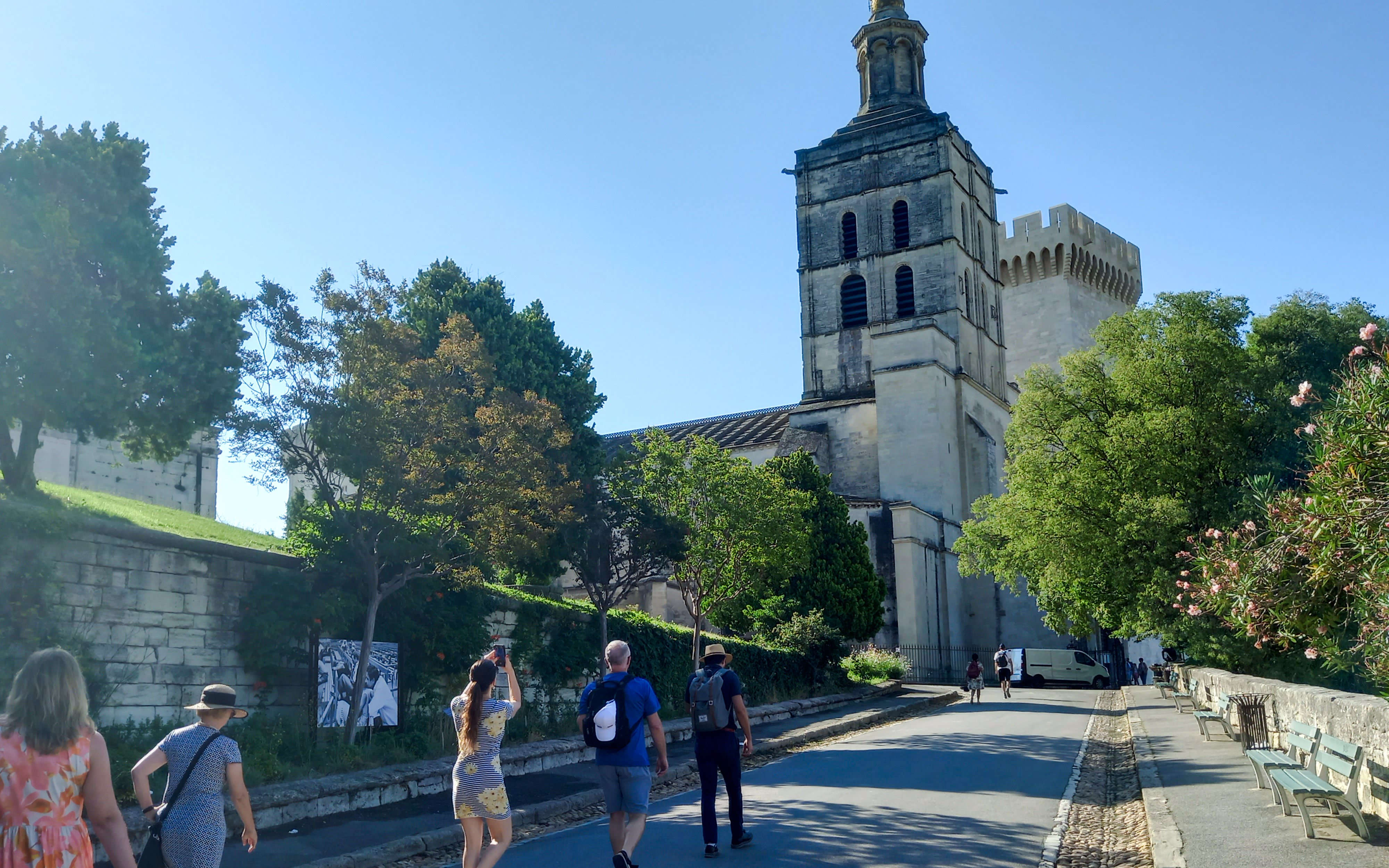 Visitors walking towards the Papal Palace in Avignon, France.