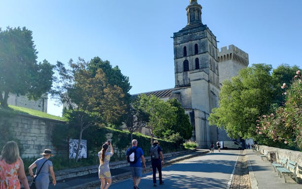 Visitors walking towards the Papal Palace in Avignon, France.