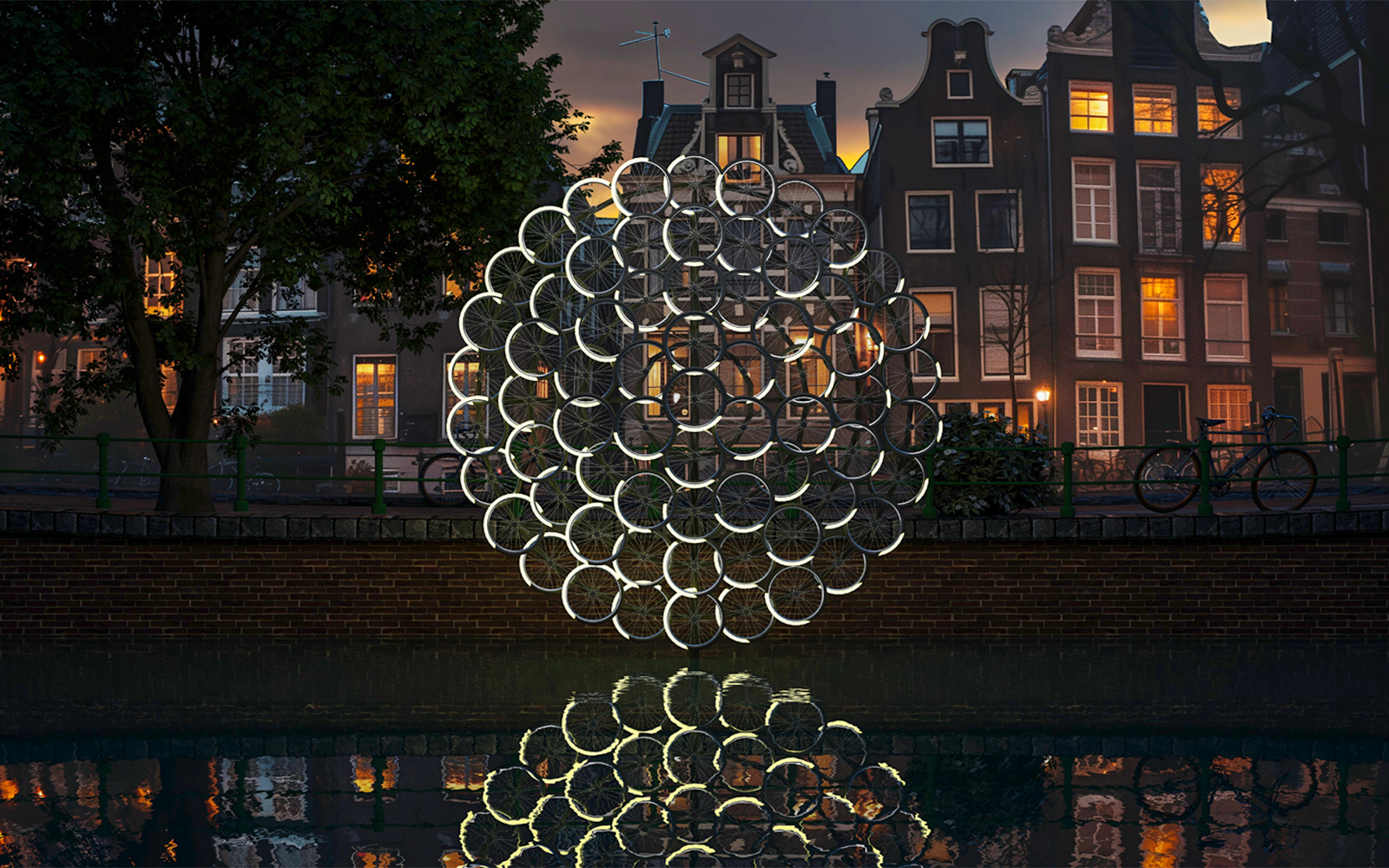 Illuminated bicycle wheel sculpture at Amsterdam Lights Festival with canal houses in the background.