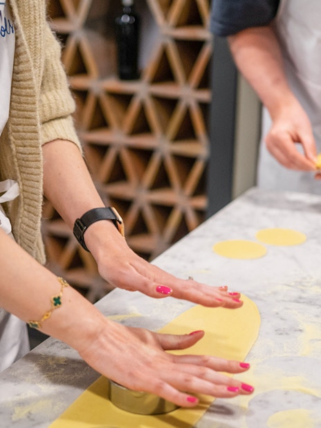Hands preparing pasta dough at a cooking class in Rome.