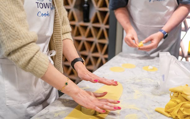 Hands preparing pasta dough at a cooking class in Rome.