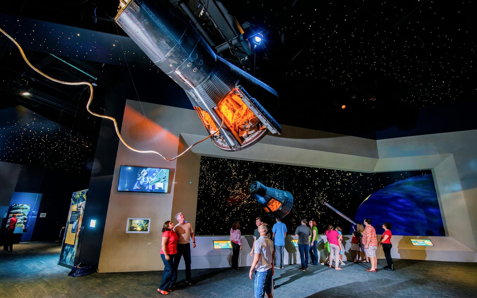 Visitors exploring spacecraft exhibits at Space Center Houston.