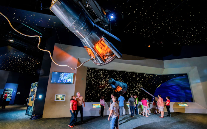 Visitors exploring spacecraft exhibits at Space Center Houston.