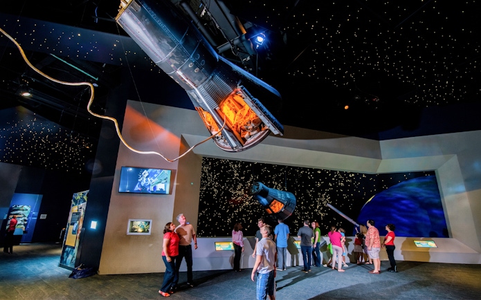 Visitors exploring spacecraft exhibits at Space Center Houston.