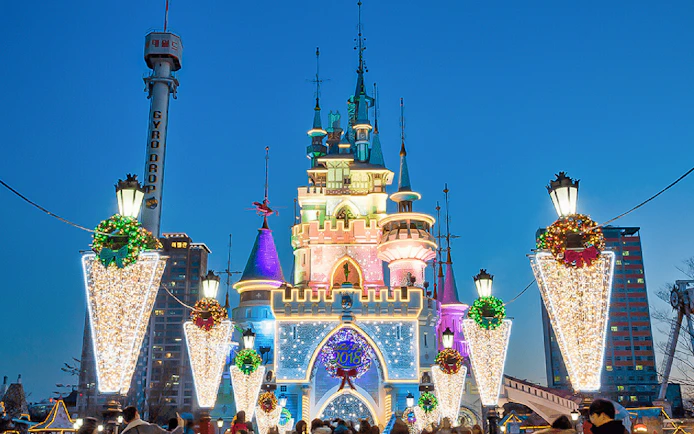 Lotte World castle illuminated at night with festive decorations, Seoul, South Korea.