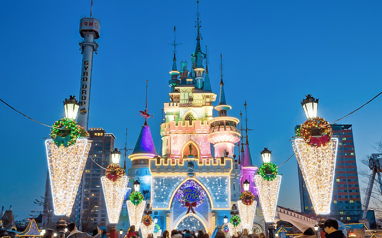 Lotte World castle illuminated at night with festive decorations, Seoul, South Korea.