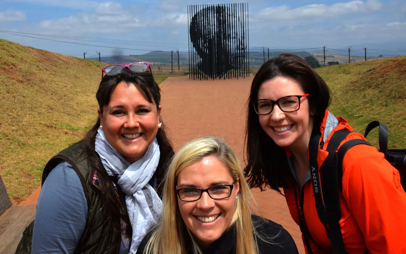 Visitors at Mandela Capture Site with sculpture in the background, South Africa.