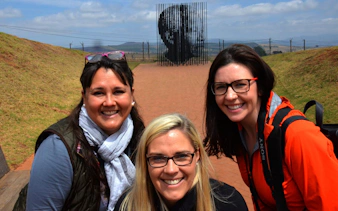 Visitors at Mandela Capture Site with sculpture in the background, South Africa.
