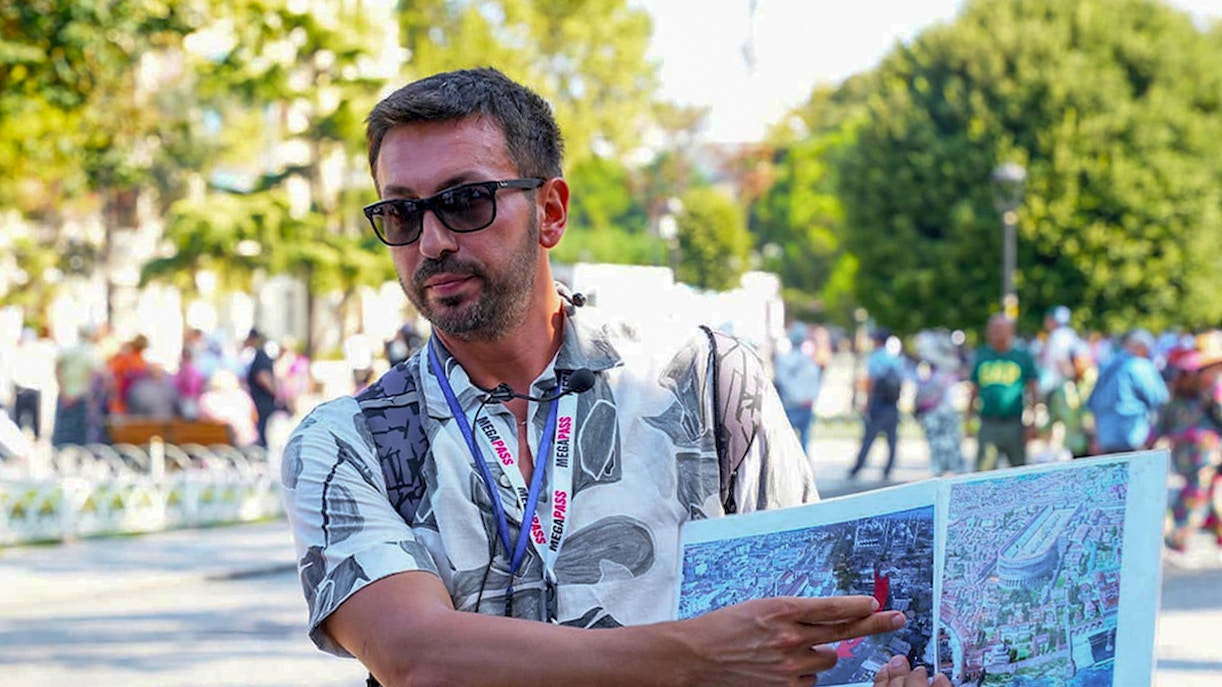 Tour guide explaining maps during Blue Mosque tour in Istanbul.