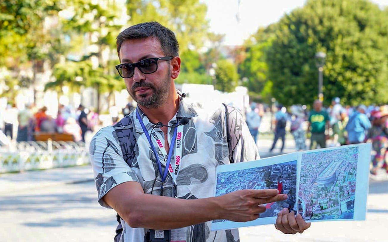 Tour guide explaining maps during Blue Mosque tour in Istanbul.