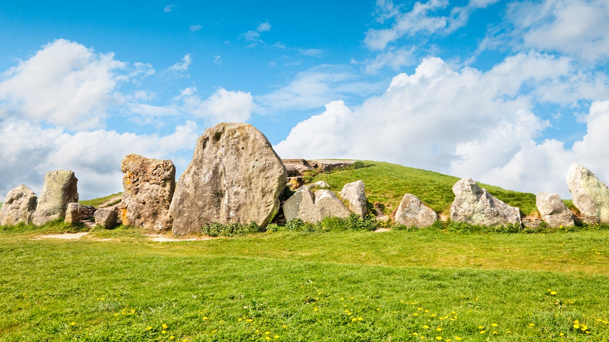 Avebury stone circle under a blue sky, part of a full-day tour from London.