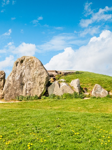 Avebury stone circle under a blue sky, part of a full-day tour from London.