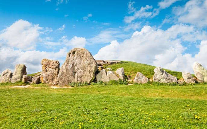 Avebury stone circle under a blue sky, part of a full-day tour from London.