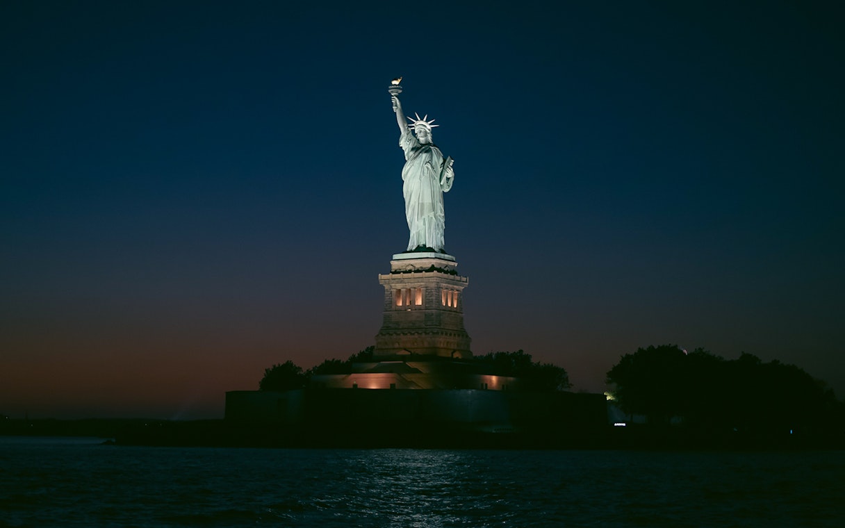 Statue of Liberty illuminated at night, New York City.