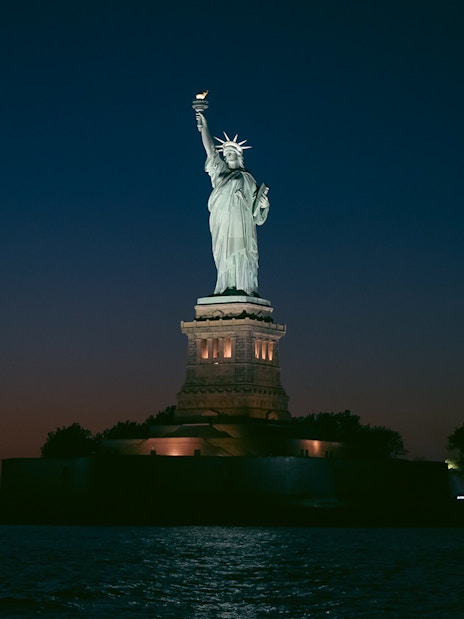 Statue of Liberty illuminated at night, New York City.