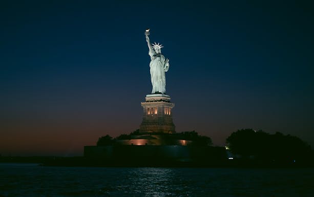 Statue of Liberty illuminated at night, New York City.