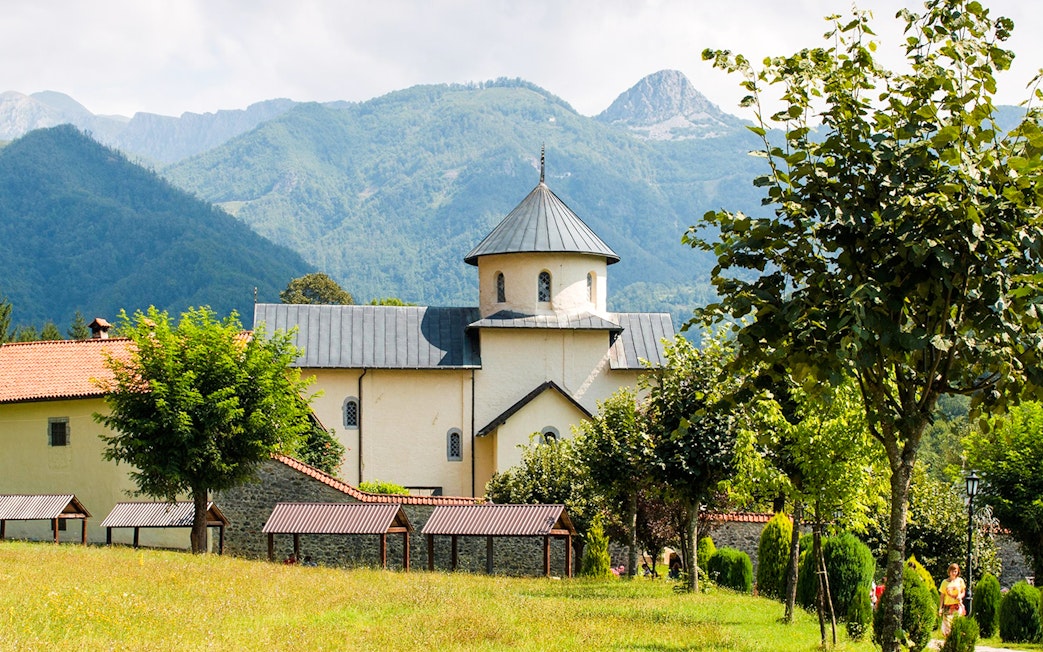 Morača Monastery with mountainous backdrop and surrounding greenery.