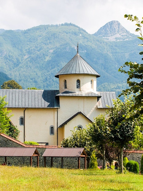 Morača Monastery with mountainous backdrop and surrounding greenery.
