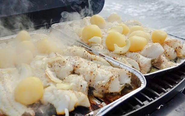 Grilled fish and potatoes on a BBQ during Reykjavík Sea Angling Gourmet tour.