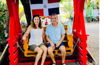 Couple sitting on a swing under Dominican flag at Punta Cana craft market.