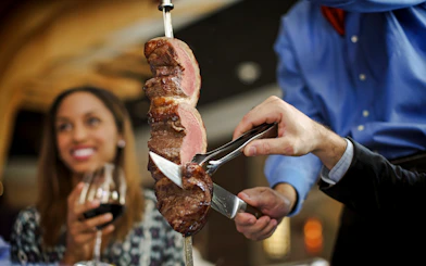 Server slicing meat at a Brazilian steakhouse in Rio de Janeiro.