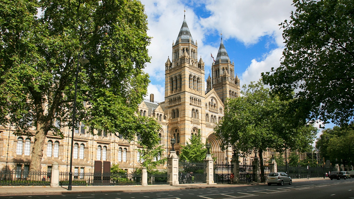 Natural History Museum London exterior with visitors and iconic Romanesque architecture.