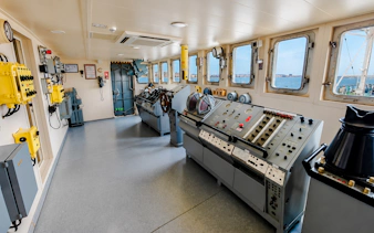 Control room of the world's first tanker museum in Baku, featuring navigation equipment and sea view.