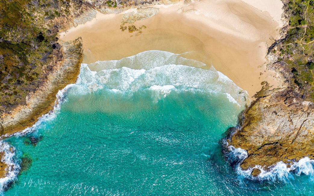 Aerial view of Honeymoon Bay's turquoise waters and sandy beach.