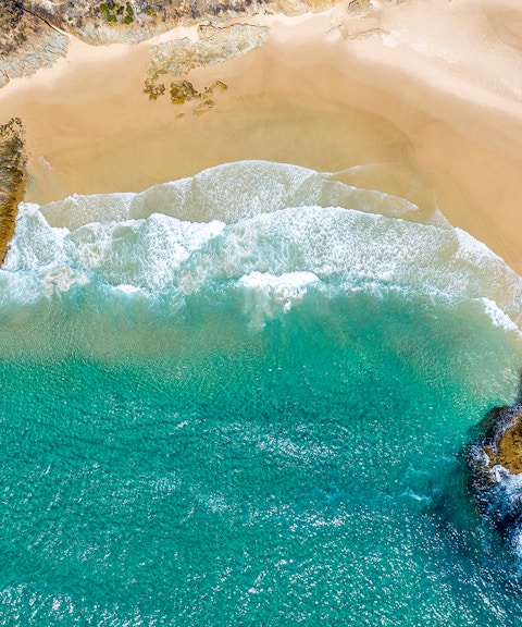 Aerial view of Honeymoon Bay's turquoise waters and sandy beach.