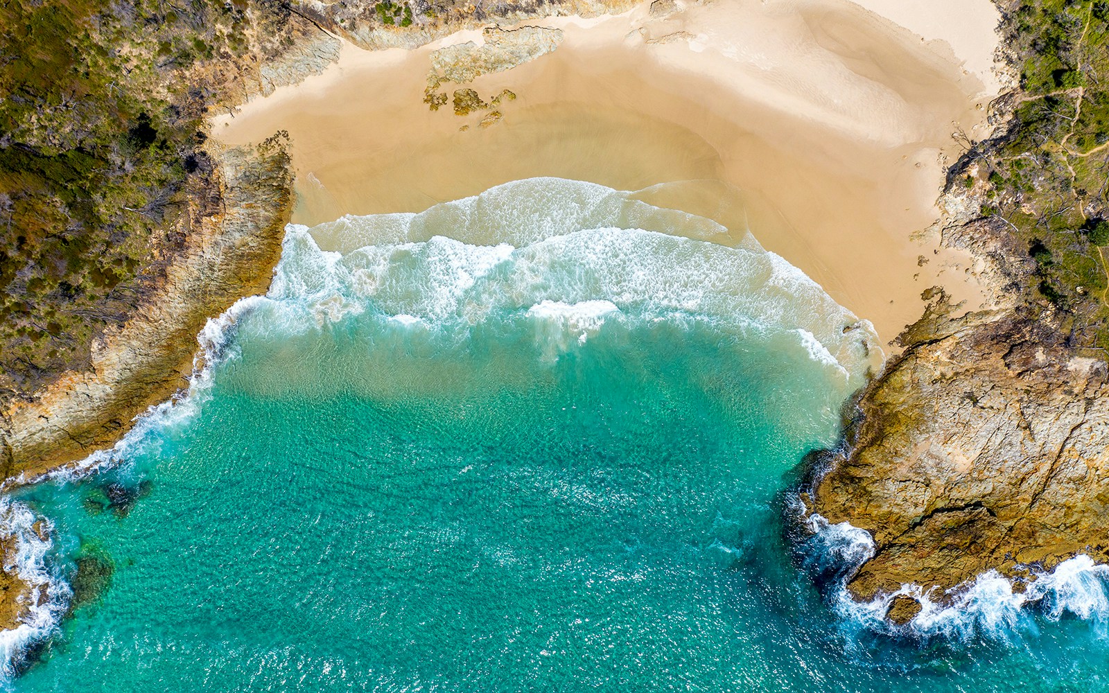 Aerial view of Honeymoon Bay's turquoise waters and sandy beach.