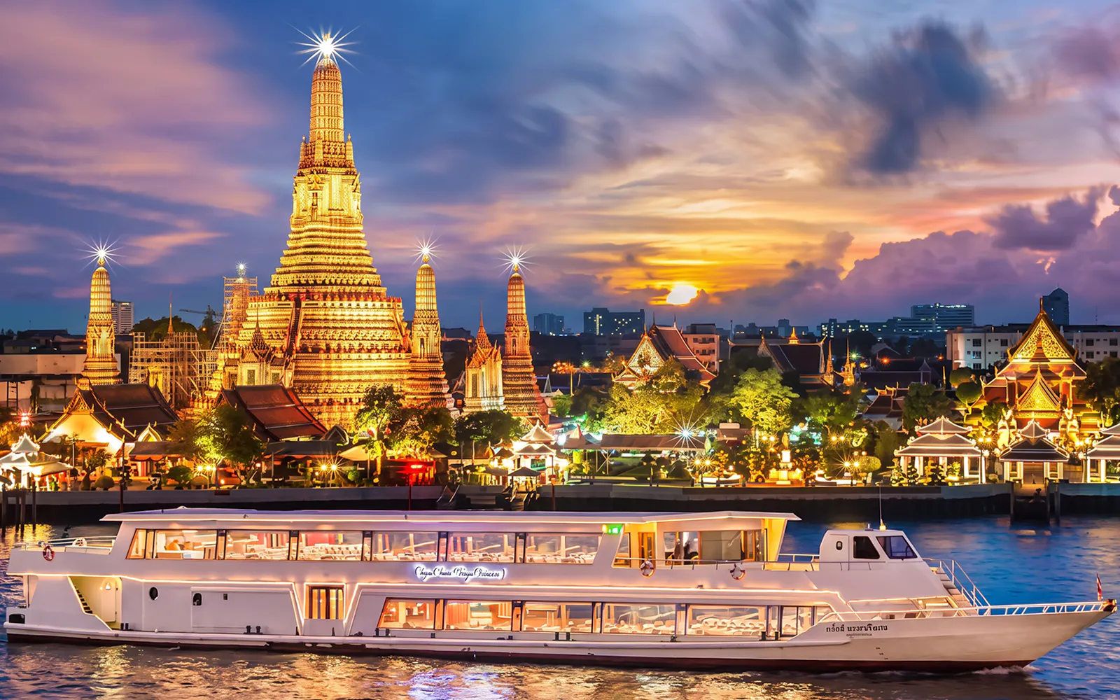 Chao Phraya Princess cruise passing Wat Arun at sunset during New Year's Eve in Bangkok.