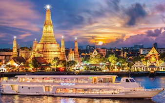 Chao Phraya Princess cruise passing Wat Arun at sunset during New Year's Eve in Bangkok.